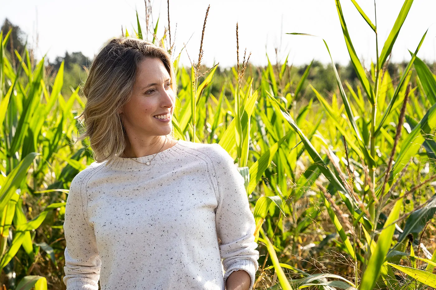 Kate Dunklee smiling on a sunny day in a corn field